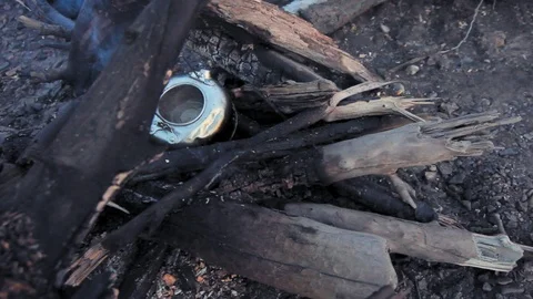 Alaska. Old kettle full of boiling water among wooden logs on a camp fire.  Video stock 116899001