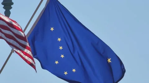 Alaska state flag and the U.S. flag blowing in the wind in slow motion Stock Footage 201302100