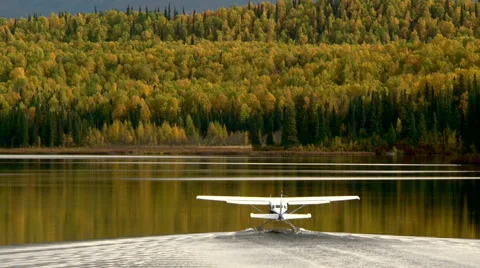 Alaskan float plane taxing away down lake in fall colors Stock Footage 40449238