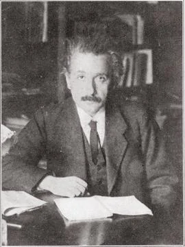 Albert Einstein seated at desk. Stock Photos