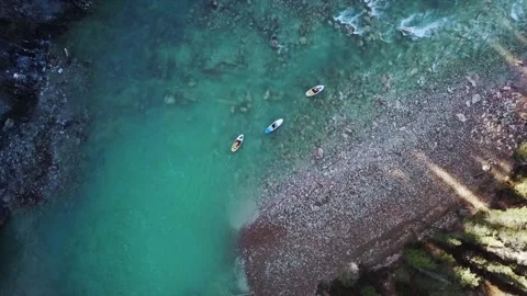 Alberta, Cananda, 17 March 2020: Three people doing SUP in a river  Stock Footage 164897556