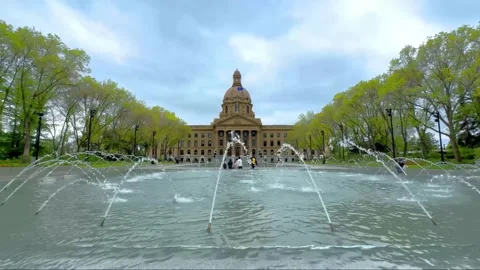 The Alberta Legislature Building, framed by spring foliage and a fountain Stock Footage 309974609