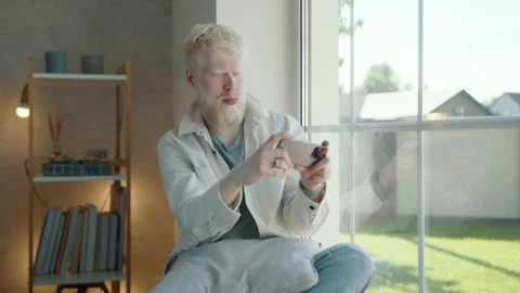 Albino man with white beard making photos of outdoor view sitting at the window Stock Footage 244848698