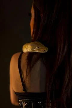 Albino molur python with a dark goth brunette girl Stock Photos