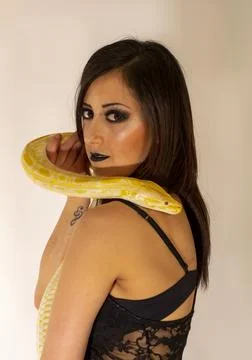 Albino molur python with a dark goth brunette girl Stock Photos