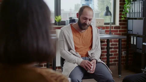 Alcohol addict crying because of mental health issues with people at aa therapy Stock Footage 165335542
