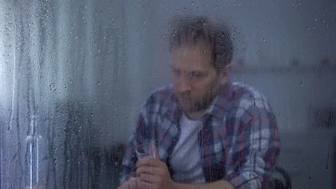 Alcohol addicted man drinking vodka in loneliness behind rainy window, problems Stock Footage 107215916