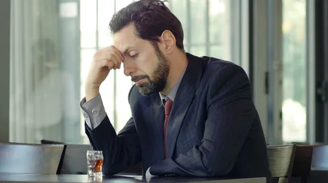Alcohol addicted man is sitting alone with a glass of alcohol in front of him Stock-Footage 48749720