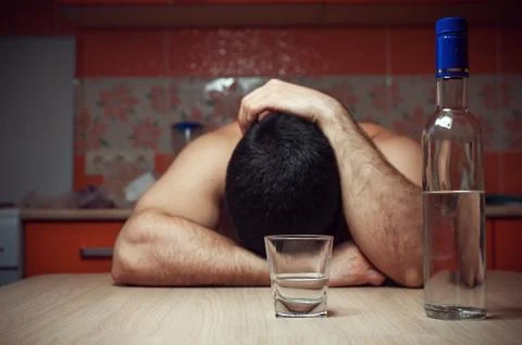 Alcohol addicted man sleeping at the table Stock Photos