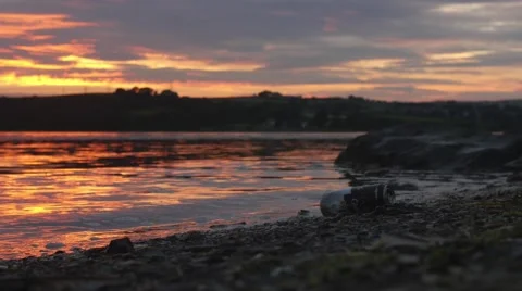Alcohol can trash on beach at sunset Stock Footage 66776908