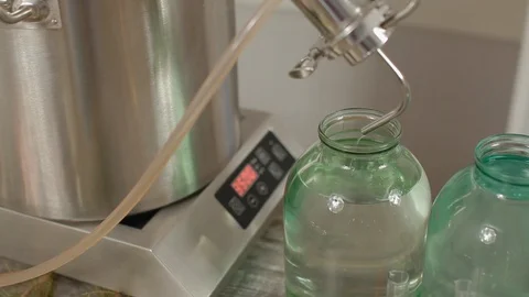 Alcohol dripping into a jar. Last step of a Distillery Where Final Product of Stock Footage 129708445