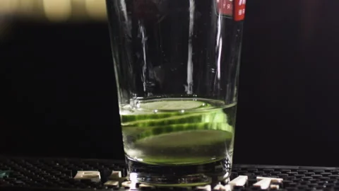 Alcohol falling on cucumbers in slow motion drink pour Stock Footage 137822617