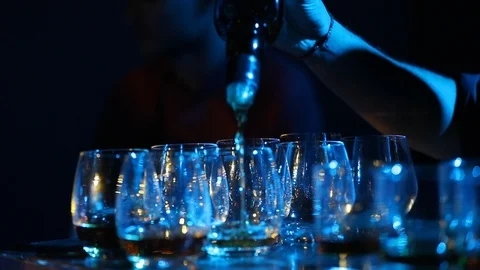 Alcohol is pouring into the angled glass Stock Footage 97732427