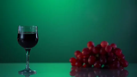 Alcohol. Two glasses with red vine and grape on the reflected surface. Green Stock Footage 167417170