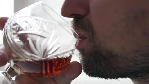 An alcoholic with an alcohol addiction problem drinks from a glass of whiskey. Stock Footage 255040383