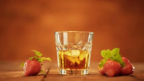 Alcoholic drink with ice cubes in cool glass and Strawberry on table Vídeos de archivo 96239871