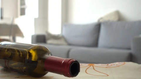 Alcoholic man gets drunk on the sofa at home. Empty bottle of wine in the foregr Stock Footage 128222108