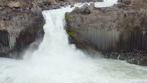 Aldeyjarfoss waterfall, powerful drop in strong current and lava field, arc shot Stock Footage 138709046