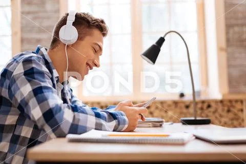 Alert boy wearing headphones and using his phone Stock Photos