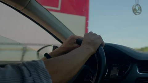 Alert driver handling vehicle amidst crowded suburban streets during daytime Stock Footage 325071410