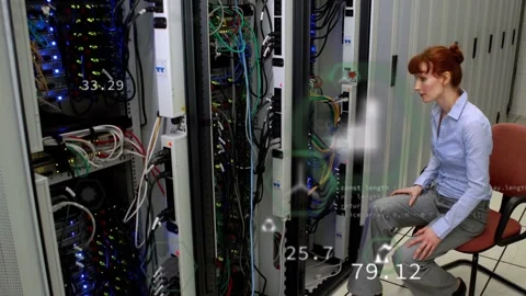 On alert, engineer leaning into racks, checking system health with updating Stock Footage 332685849