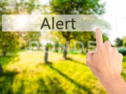 Alert - Hand pressing a button on blurred background concept on Stock Photos