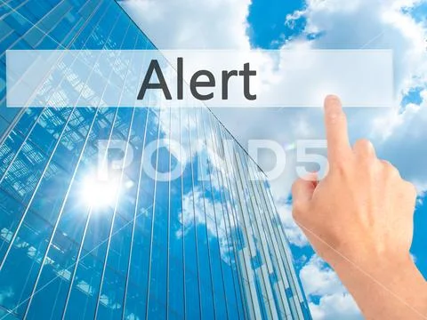 Alert - Hand pressing a button on blurred background concept on Stock Photos