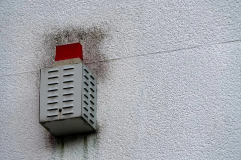Alert system mounted on wall with visible wear and mold Stock Photos