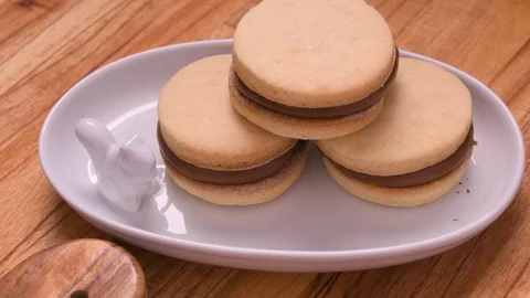 Alfajor and Dulce de Leche on White Tray with Squirrel Pan Over Wood Video stock 129351340