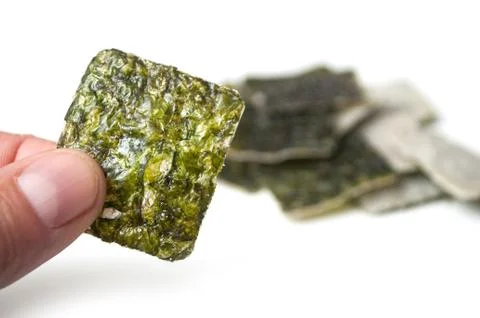 Algae chips in shaped square in hand on white background Stock Photos