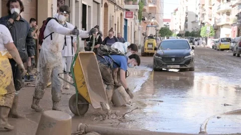 Algemesi, Spain - 11/10/2024: Volunteers using wheelbarrow to clear mud 動画素材 292250135