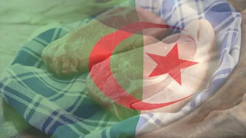 Algerian flag overlay appearing, forearm smoothing two raw poultry on checkered Stock Footage 329533353