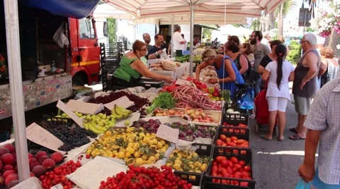 Alghero, Sardinia, July 2015 - People buying fresh produce in a bustling market Stock Footage