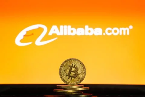 Alibaba logo on a computer screen with a stack of Bitcoin cryptocurency coins. Stock Photos
