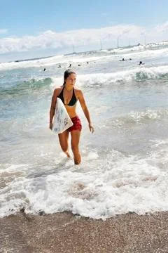 Alicia Acuna Ika exits the water after surfing near Hanga Roa Stock Photos