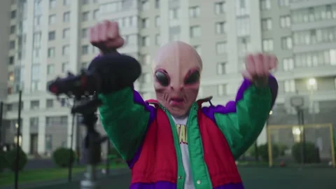 An alien dances at a microphone on the street Stock Footage 326171078