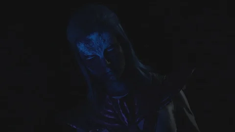Alien with a glowing face looks at the camera in the dark Stock Footage 123743444