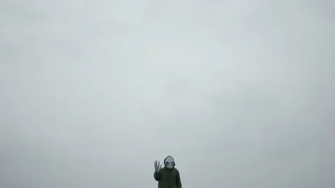 Alien in green suit stands alone in sky,alien arrived on earth rubbing his hands Stock Footage 145111102