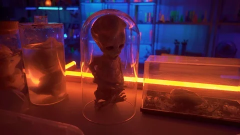 Alien mummy on table red lights creatures tubes. Red and blue light illuminate t 스톡 동영상 98817858