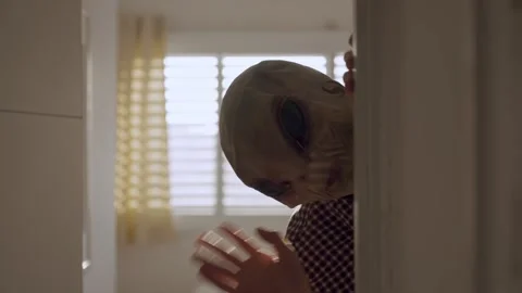 Alien peeks around doorway, creating surreal and slightly humorous scene Vídeo Stock 318457051
