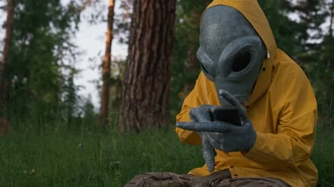 Alien in yellow suit in forest talking on the phone, UFO concept, space, Stock Footage 142121920