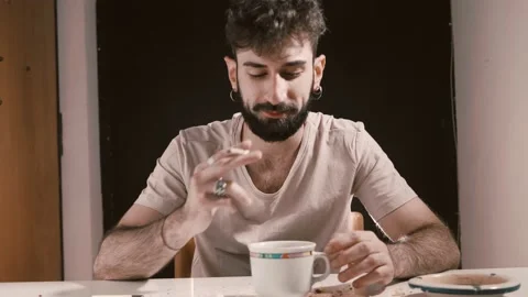 Alienation, addiction-stoned man puts ashes in the cup of tea which he drinks Stock Footage 197750722