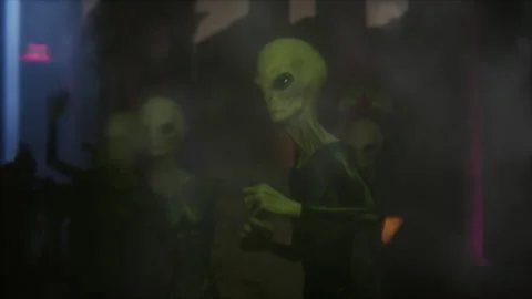 Aliens waving and dancing under vibrant stage lights Stock Footage 294880727