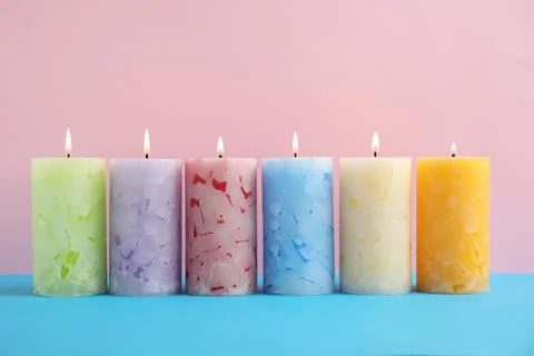 Alight scented wax candles on color background Stock Photos