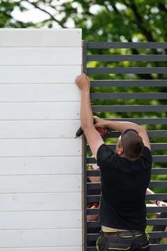 Aligning and screwing together the components of a wooden gazebo, Stock Photos