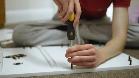 Aligning assembly dowel on drawer panel during dresser assembling Stock Footage 328370598