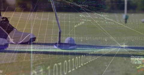 Aligning golf putter head over ball at putting green, with spiked shoe and Stock Photos