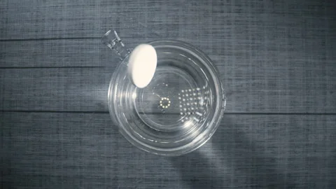 Alka Seltzer tablets fall into glass of water and dissolves in slow motion Video stock 154144808