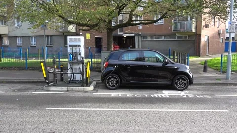 An all electric Smart EQ ForFour plug-in car at an electric charging point Stock Footage 143432742