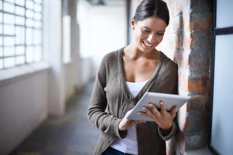 All the functionality I need. A gorgeous young woman using her digital tablet in Stock Photos
